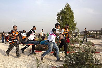 Sanitäter des medico-Partner PMRS versorgen einen verletzten Demonstranten nahe des Checkpoint bei Beit El. (Foto: Anne Paq)