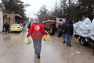 Eine Helferin des Kurdischen Roten Halbmonds mit Lebensmitteltüten