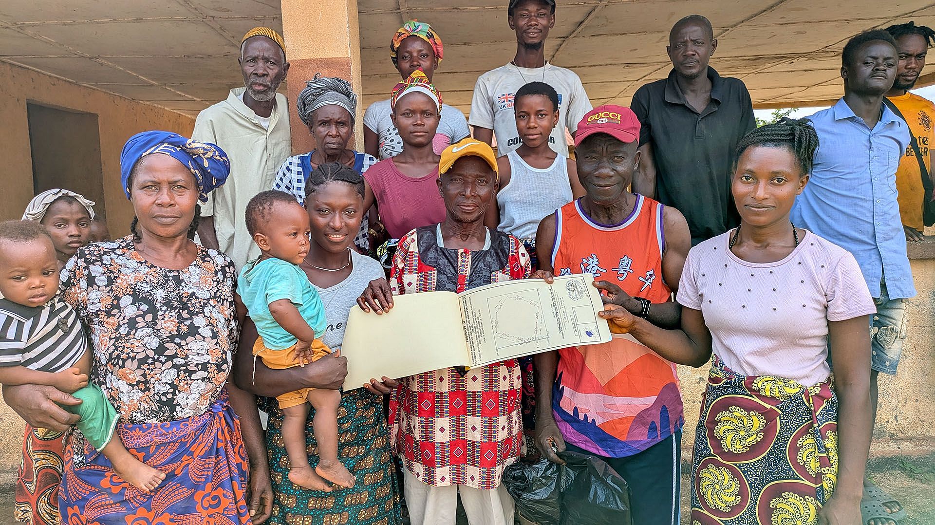 Bäuer:innen aus dem Dorf Tikonko halten ihr Landzertifikat in Händen.