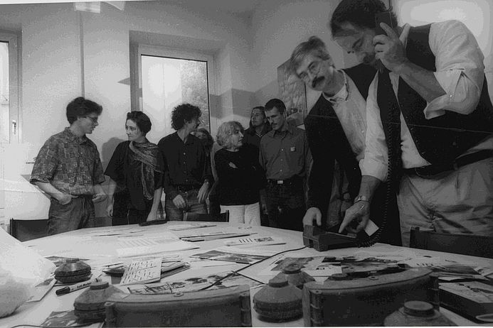 Großer Rummel um medico... medico-Mitarbeiter im Büro. Tisch mit Minenteilen.