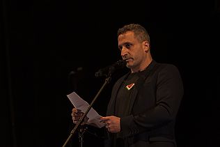 Riad Othman spricht in ein Mikrophon.