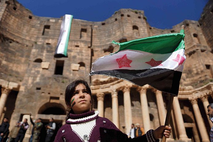 Eine Frau demonstriert im antiken römischen Amphitheater in der Nähe von Daraa.