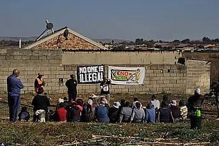 Eine Gruppe sitzt vor Plakaten in einem Workshop.