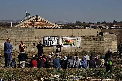 Eine Gruppe sitzt vor Plakaten in einem Workshop.