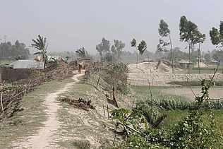 Das Bild zeigt eine Landschaft in Bangladesch, über die ein Sturm fegt.