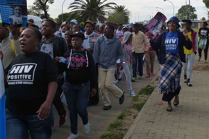 Frauen in Südafrika mit Schildern auf einer Demonstration.
