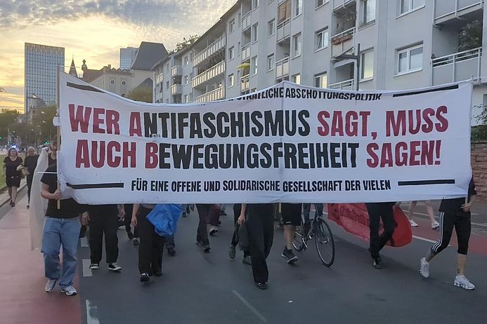 Demonstrant:innen tragen ein Transparent: "Wer Antifaschismus sagt, muss auch Bewegungsfreiheit sagen"